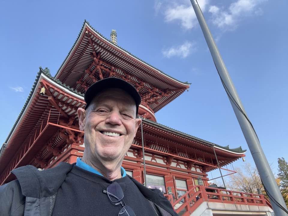 John smiling in front of a red temple in Tokyo, Japan